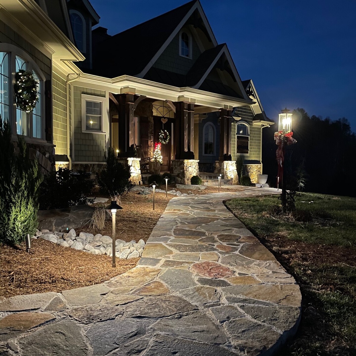 Landscape lighting along a flagstone walkway at dusk
